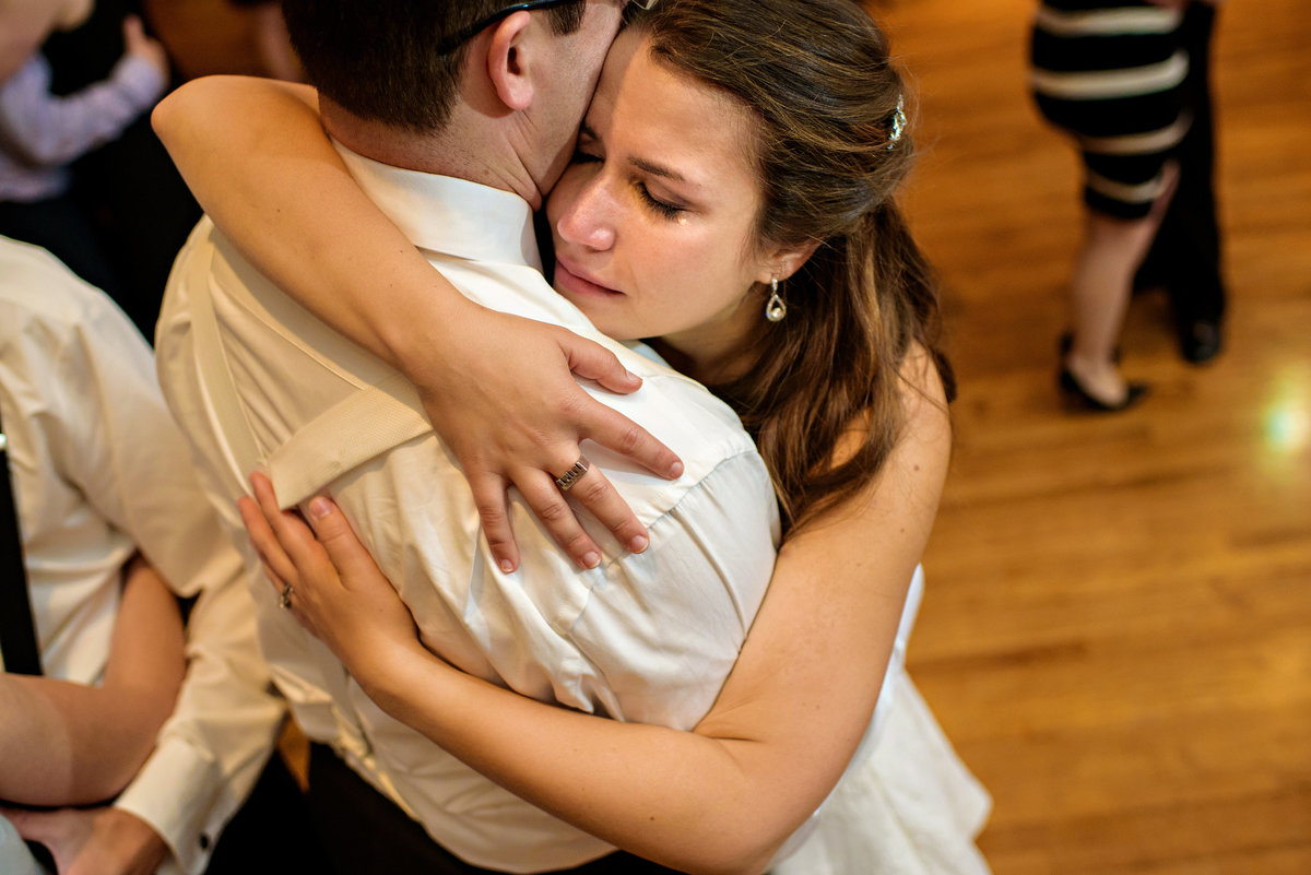 A bride sheds a tear during the last dance of the night with her groom.