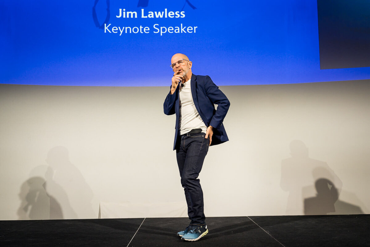 Professional headshot style of keynote presenter holding microphone speaking confidently on stage during event new york.