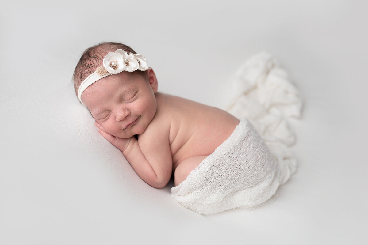 Smiling Newborn Photo in White Themed Photoshoot