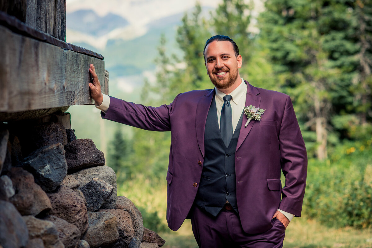 groom leaning on wall