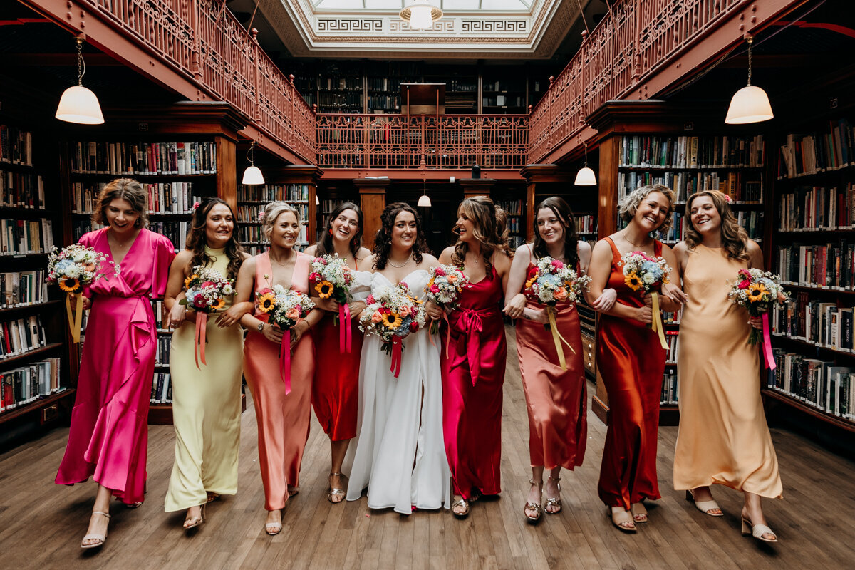 Bride and bridesmaids in colourful dresses at The Leeds Library
