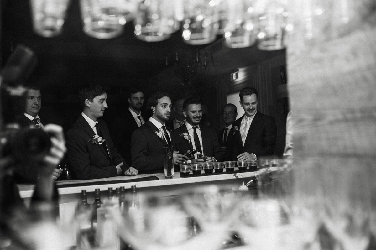 candid shot of groom and groomsmen at bar