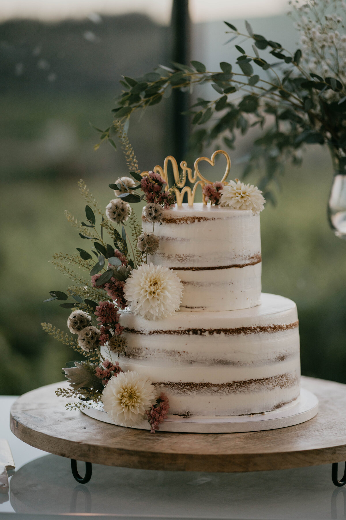 naked wedding cake with florals at vineyard wedding