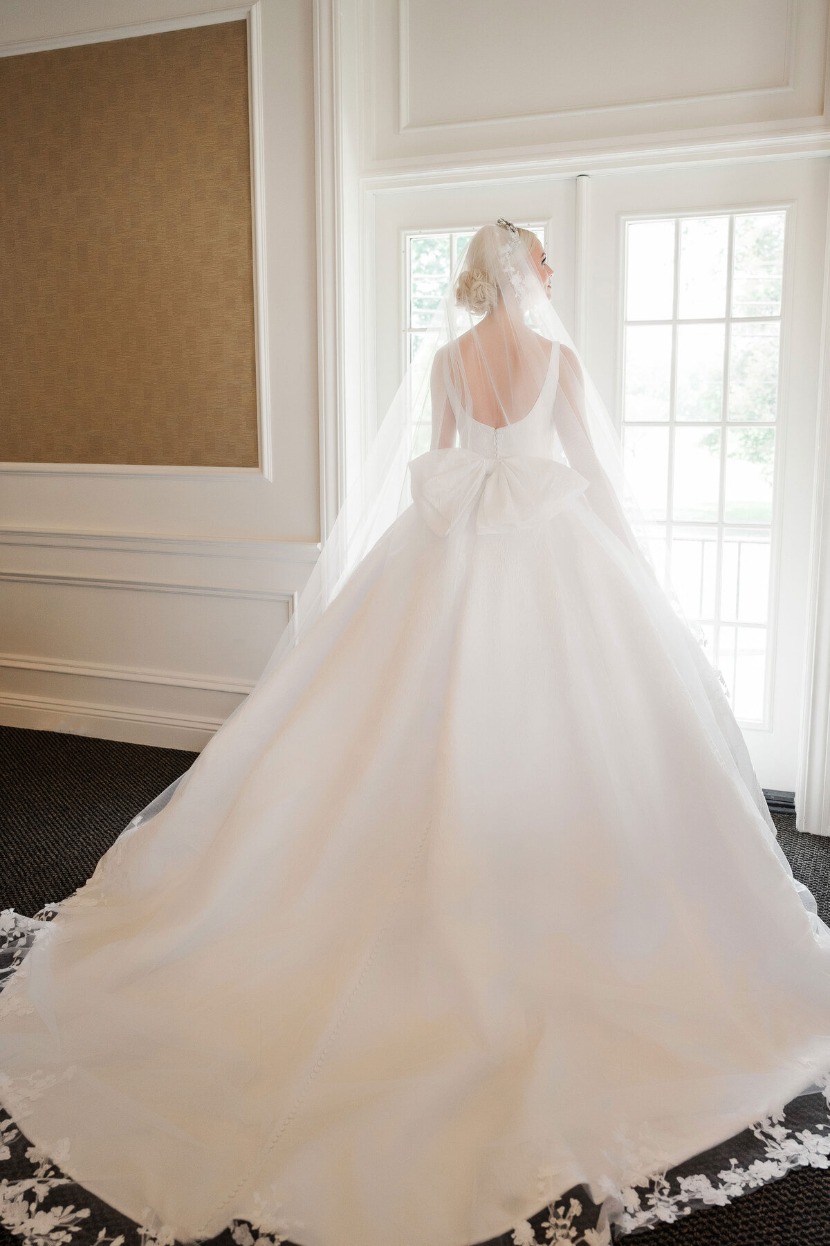 bride looking out the window on her wedding day at The Grand Resort warren ohio