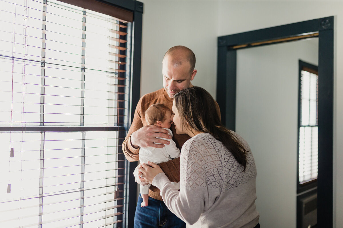 Family Photoshoot Session with mom, and dad holding newborn baby.