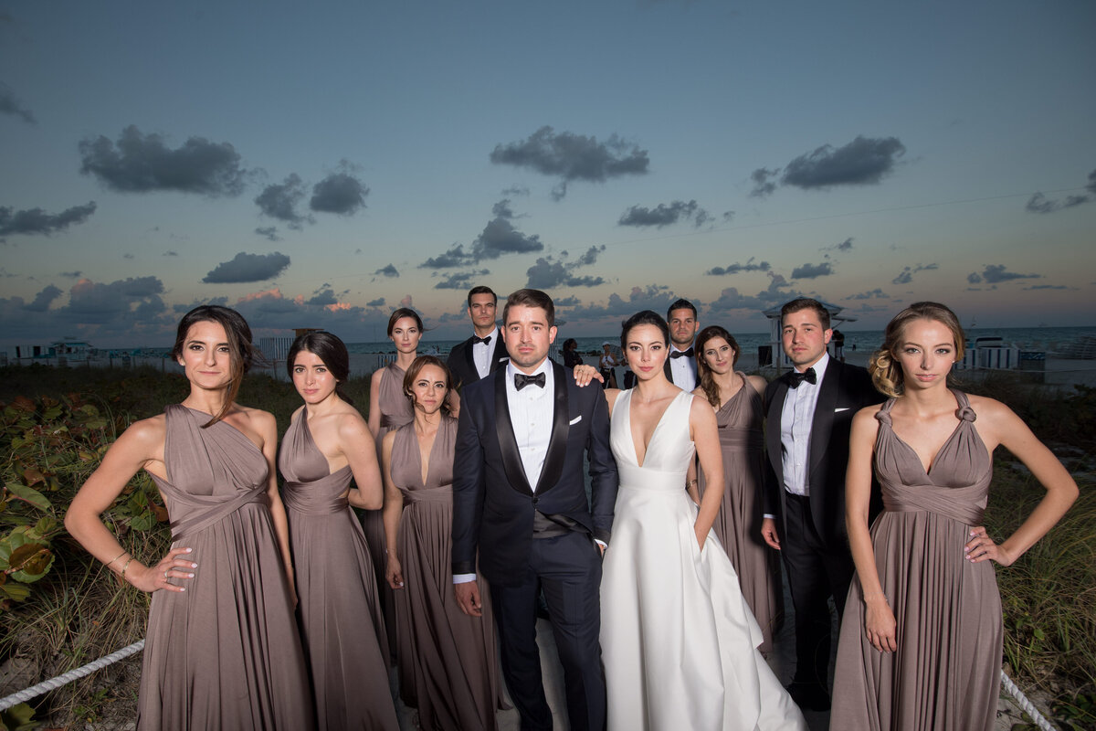 Bridal party posing on the beach at sunset, captured by Rodrigo Varela Photography.