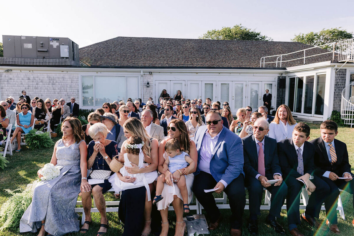 The guests are seated in an outdoor wedding ceremony at Wianno, Cape Cod, MA.
