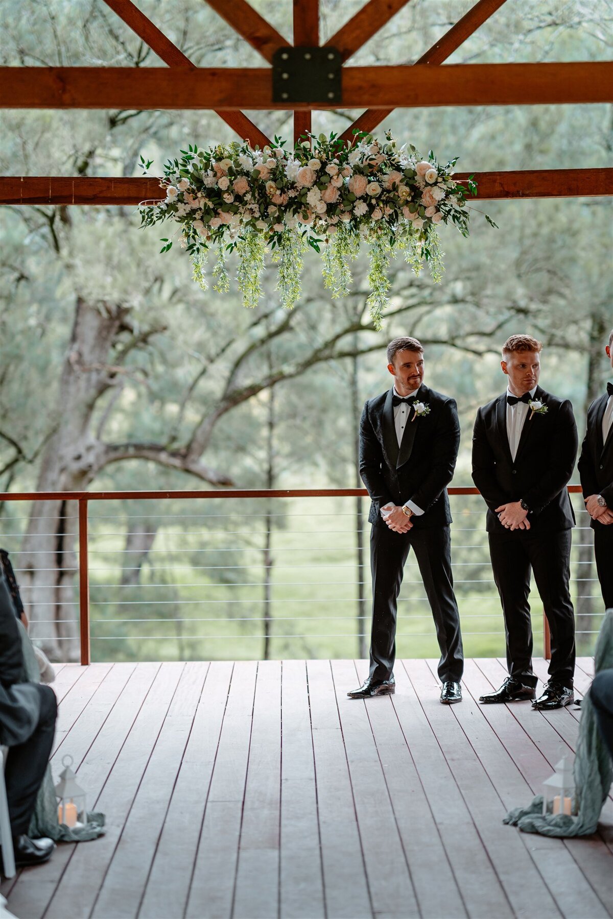The groom stands teary-eyed and emotional, eagerly anticipating the arrival of his bride.