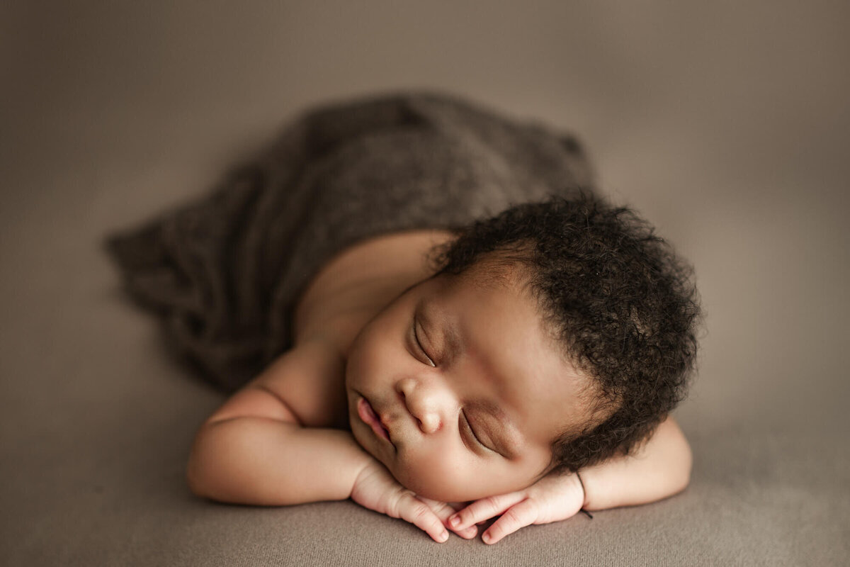 infant posed laying in hands asleep