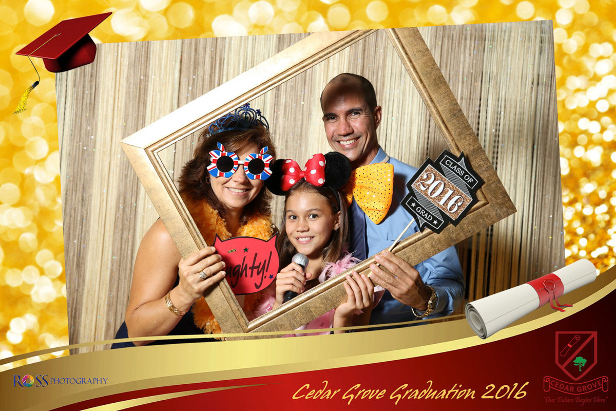 Man, woman, and little girl hold photobooth props. Photobooth by Ross Photography, Trinidad, W.I..
