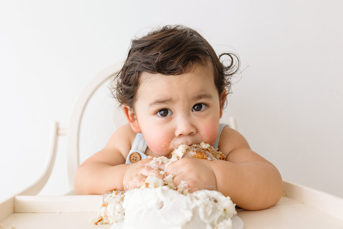 toddler boy biting into cake