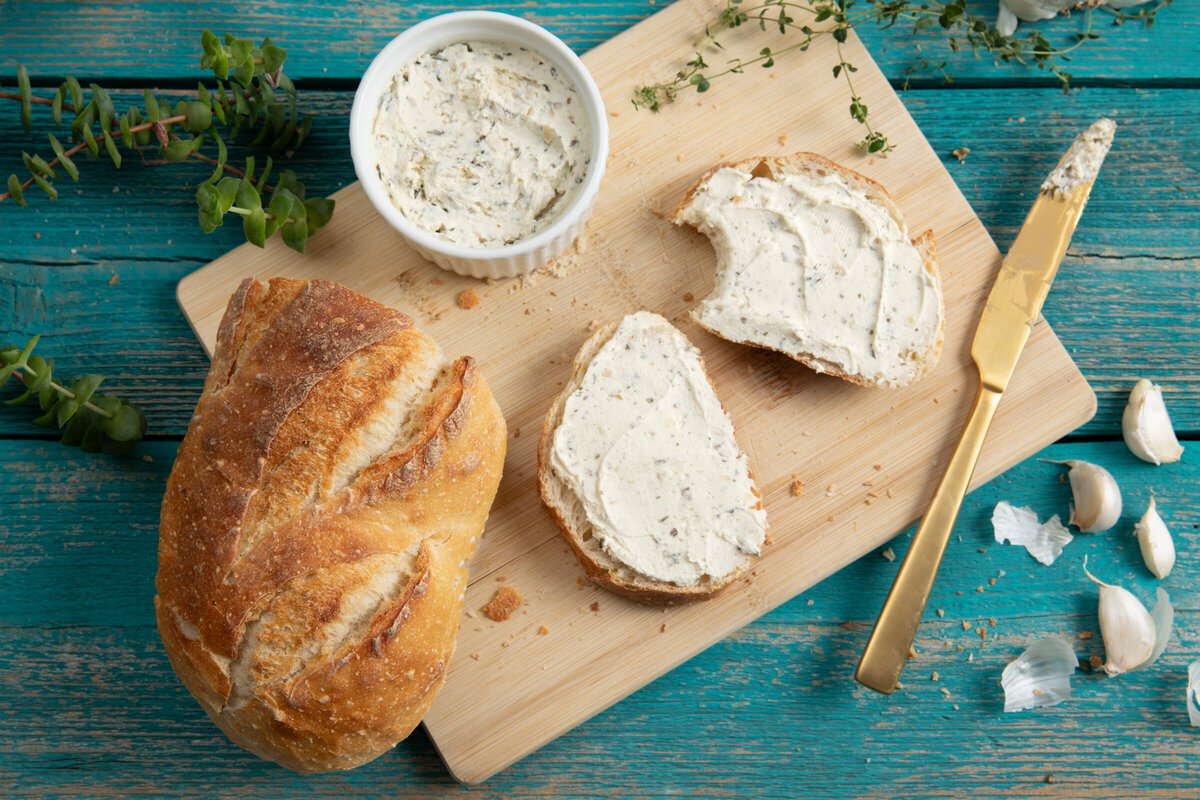 Sourdough toast with Alouette garlic and herb cheese spread on a rustic table.