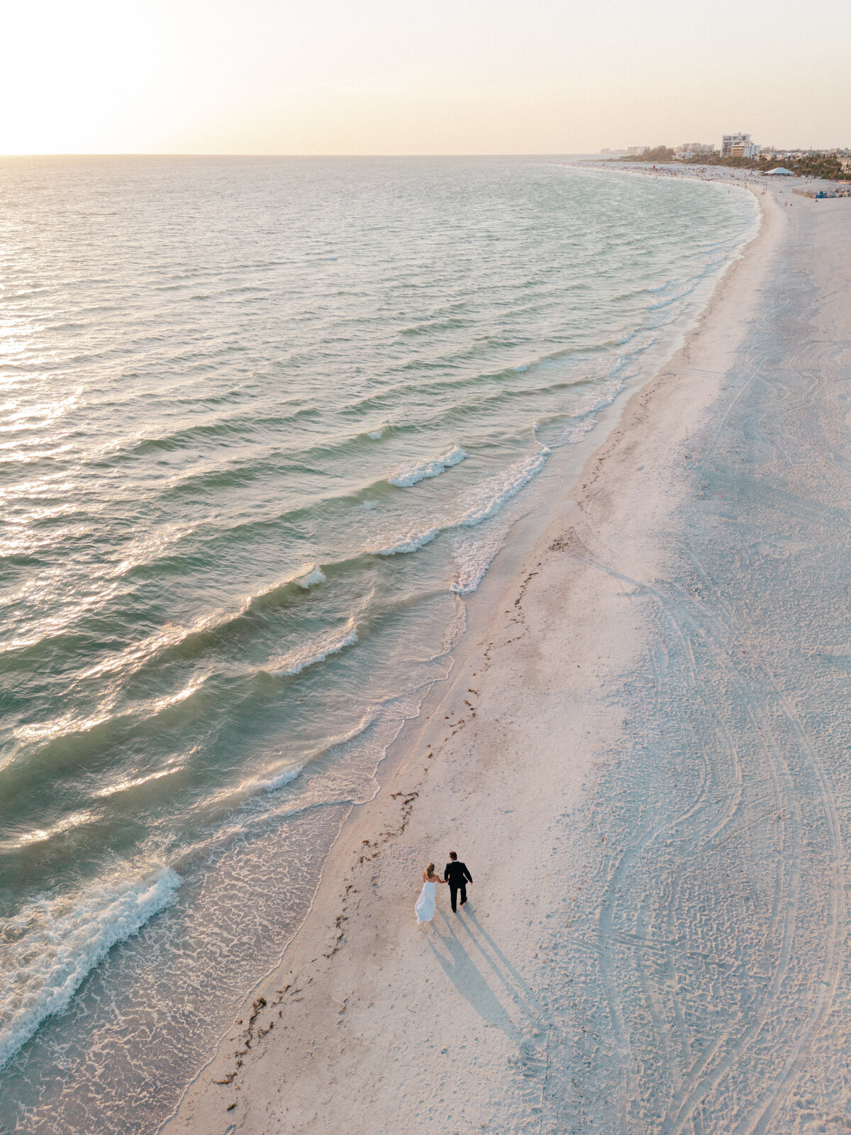 Bride and groom walking on beach