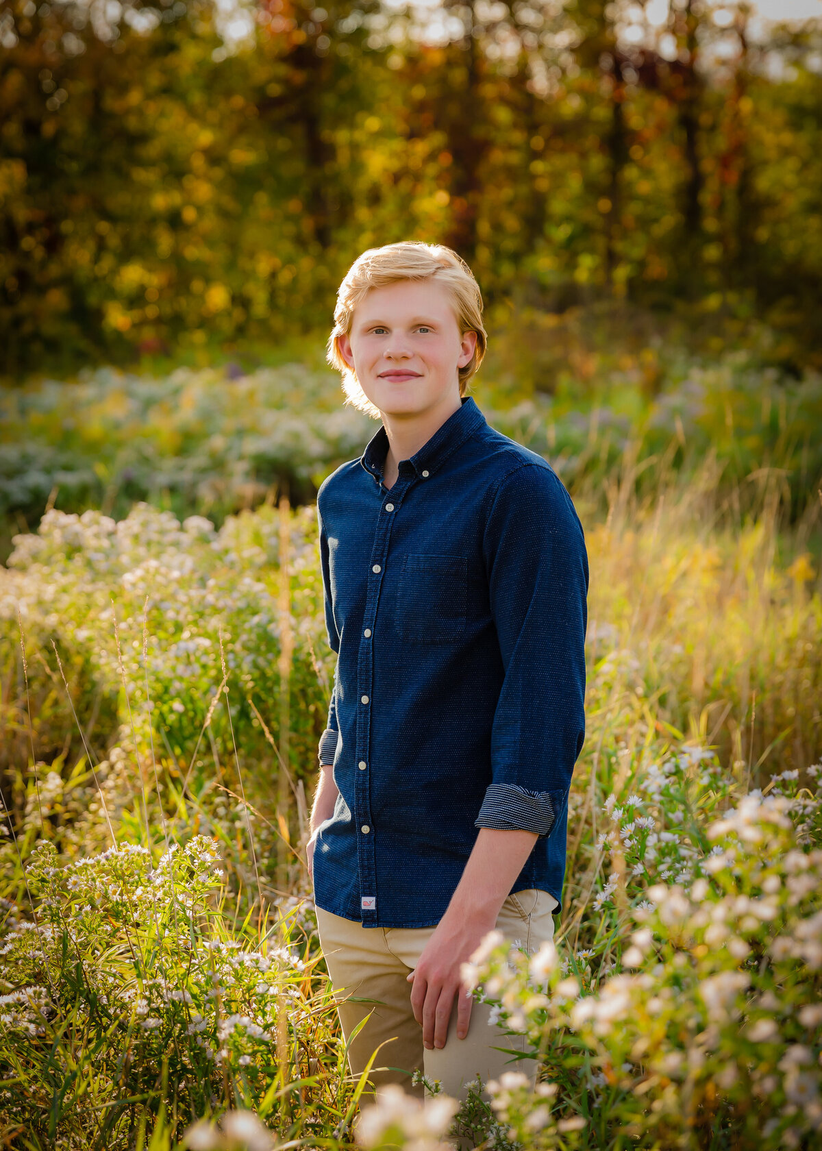 Boy standing in field at golden hour for his senior pictures