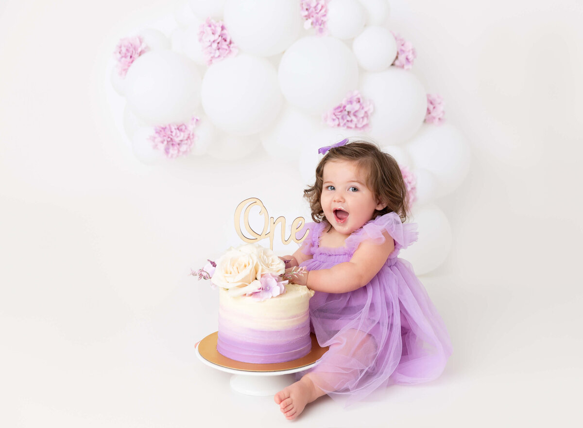 baby girl lilac flowers white balloon garland  baby girl wearing lilac dress