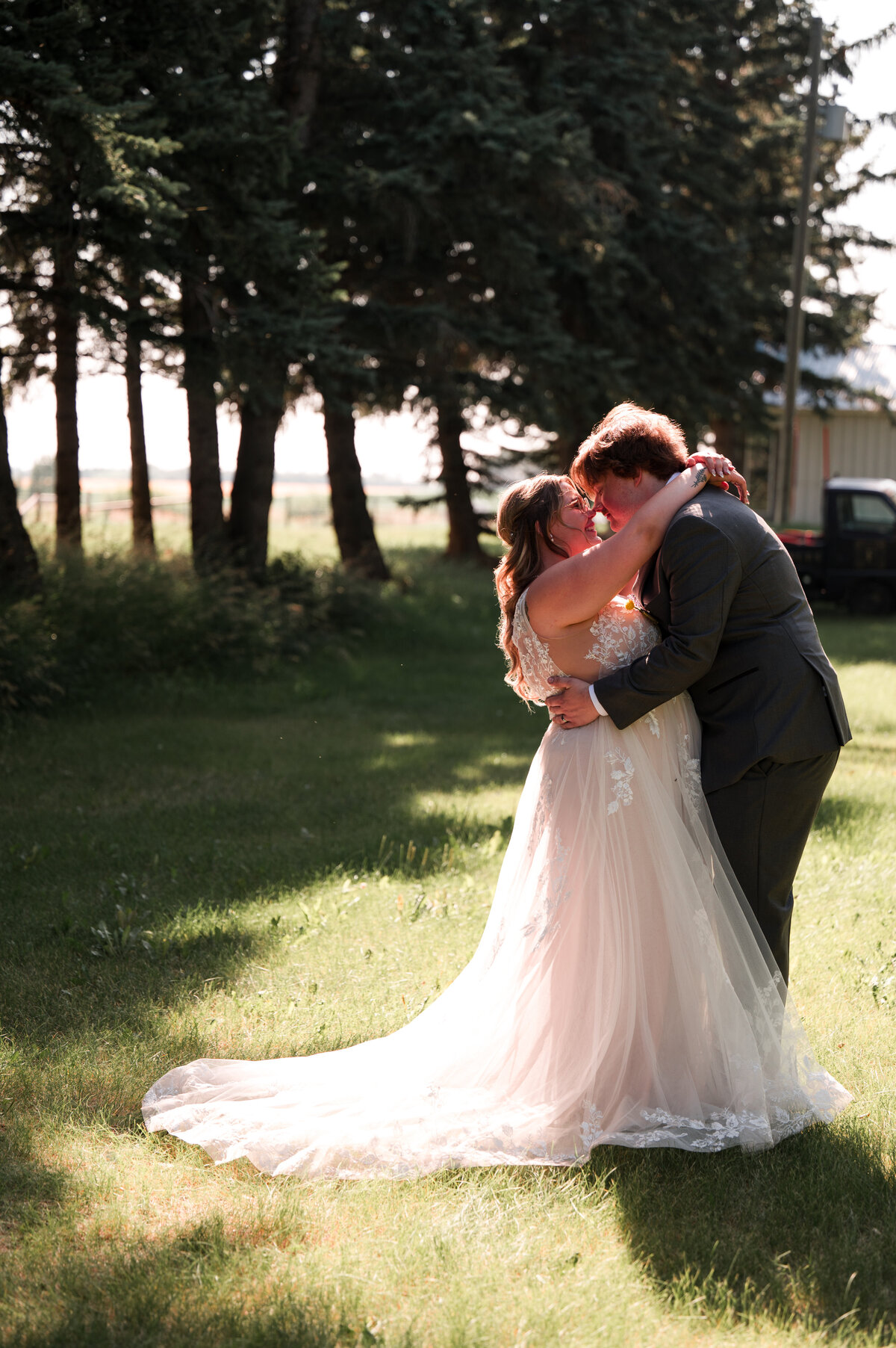 Summer wedding portrait of bride and groom in a field taken by Ember Dawn Photography