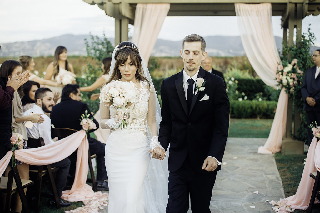 Wedding Photograph Of Bride And Groom Holding While Walking The Aisle Los Angeles