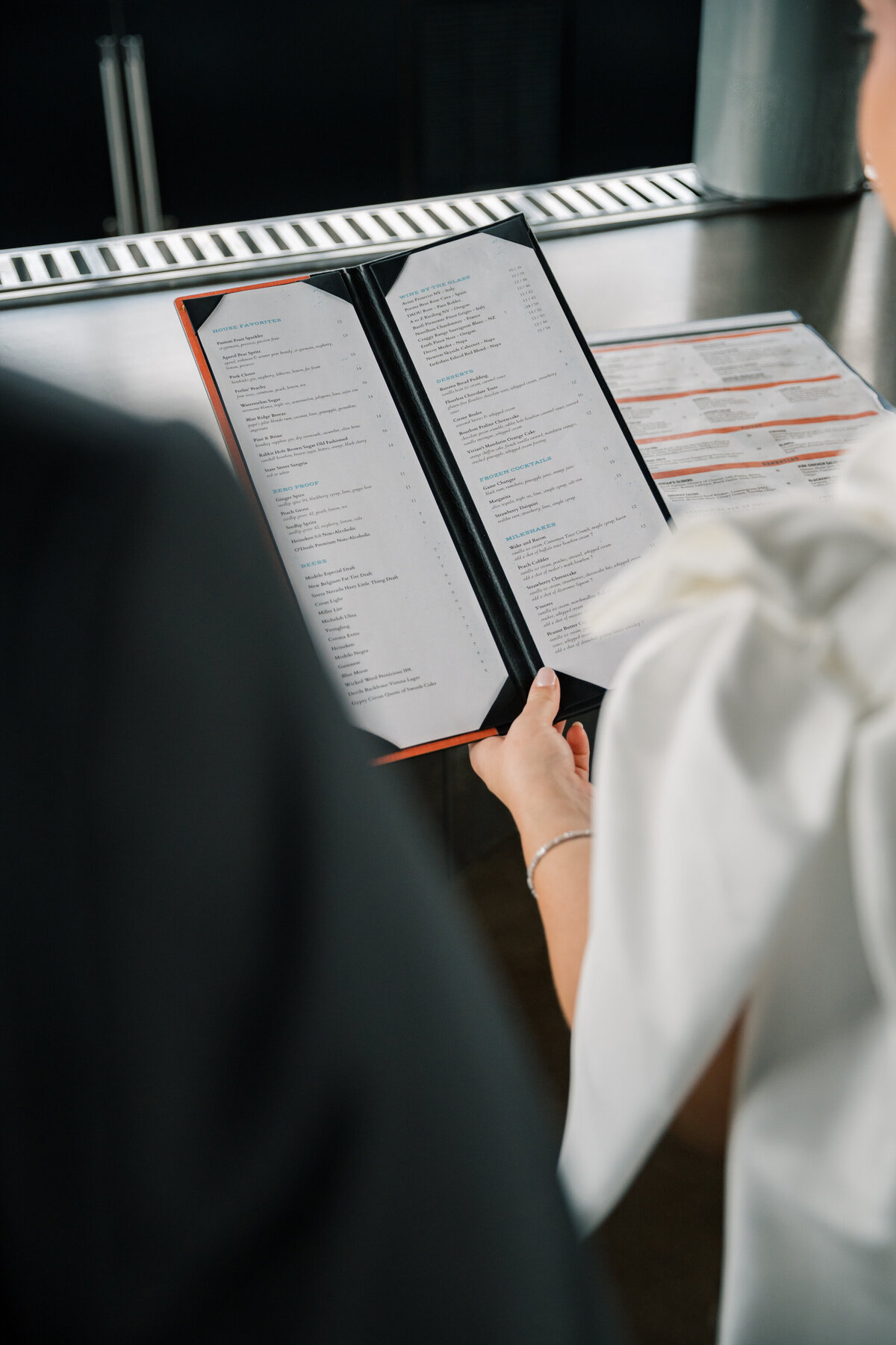 Bride and groom holding a menu in the Bristol Hotel Lumac rooftop bar before their Bristol Train Station wedding