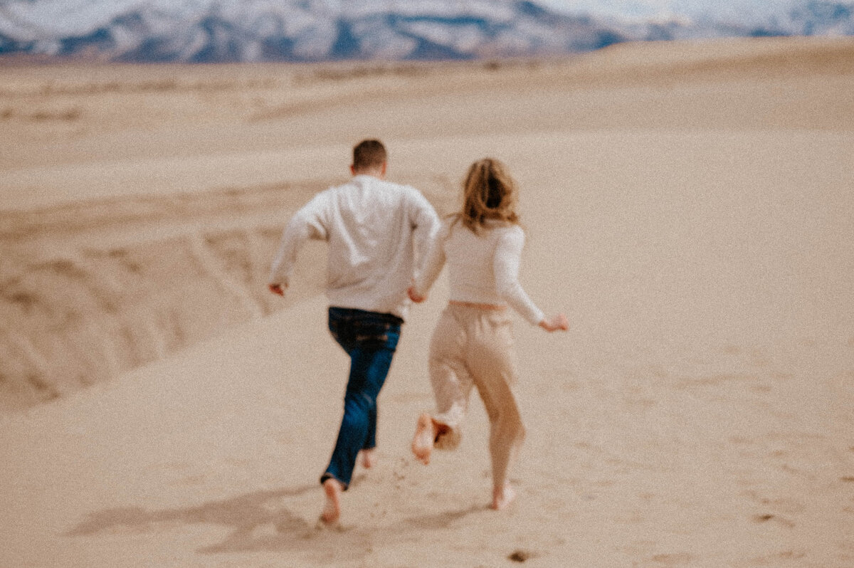 Engaged couple running on the beach