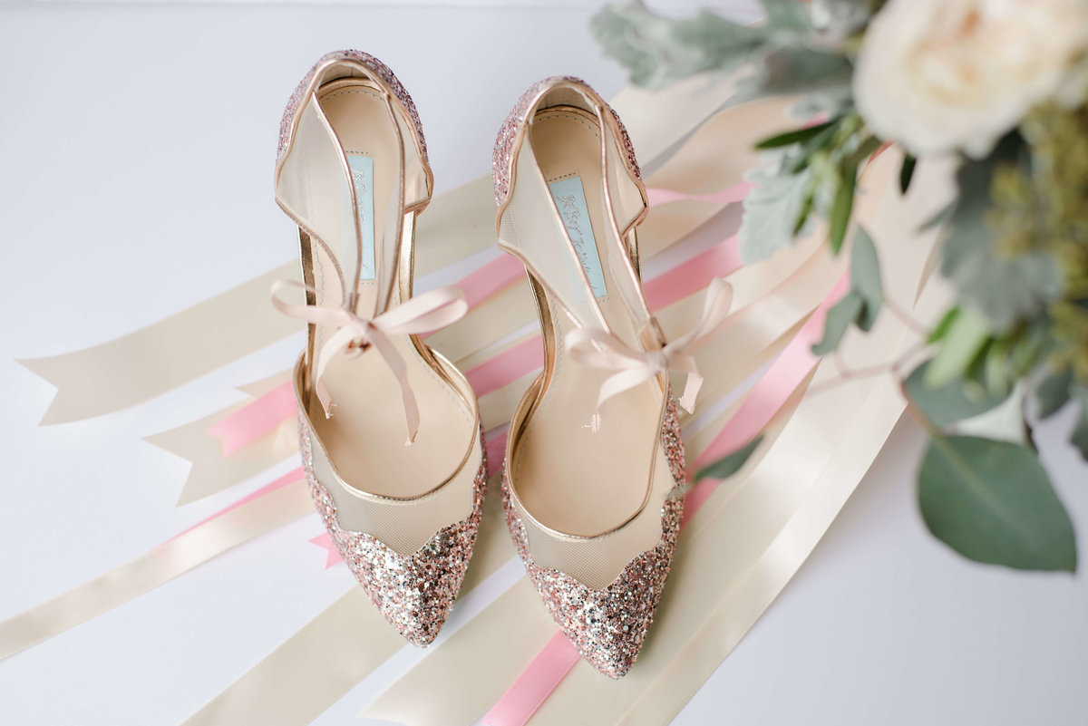 Wedding heels on top of ribbons from the bridal bouquet