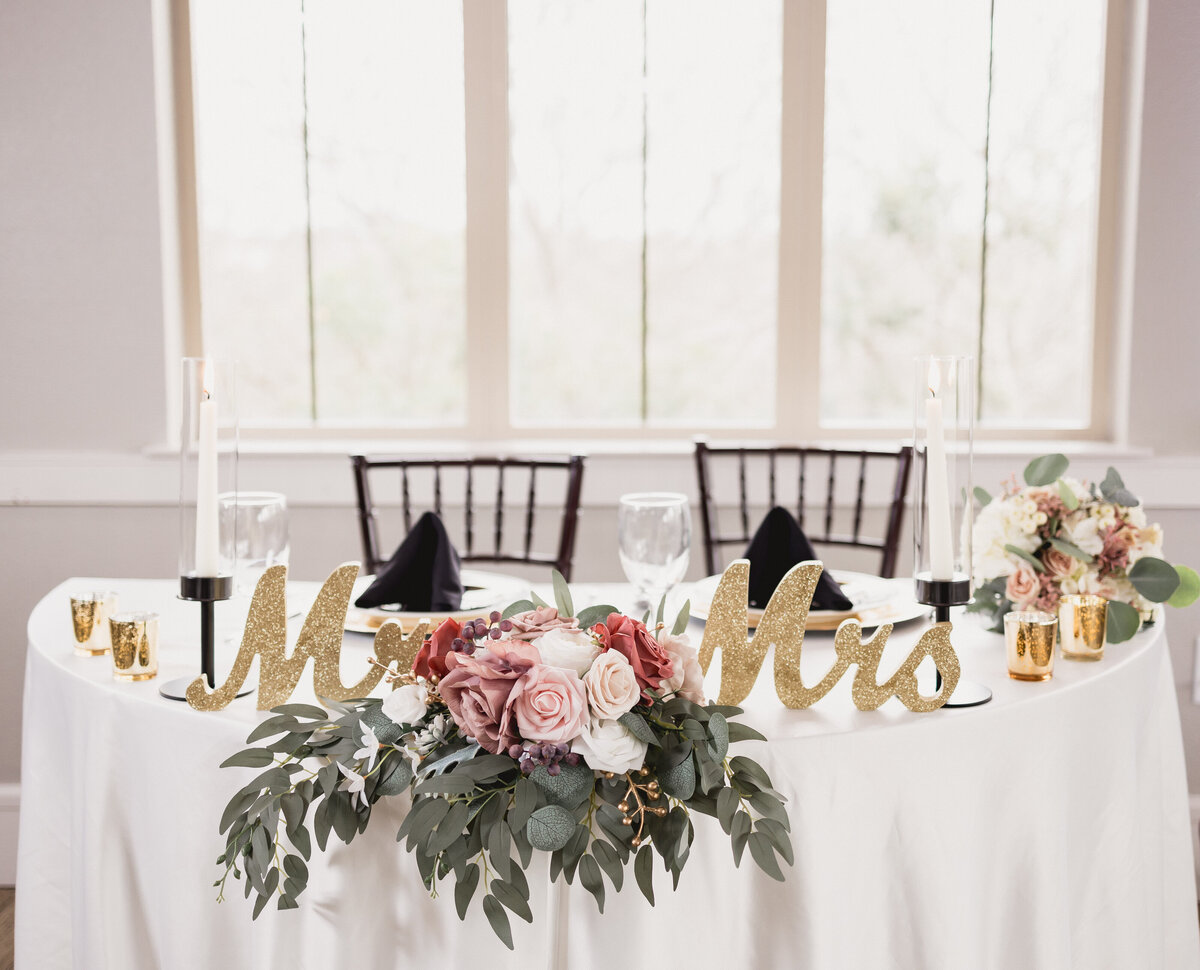 Sweetheart table with gold Mr and Mrs table decor