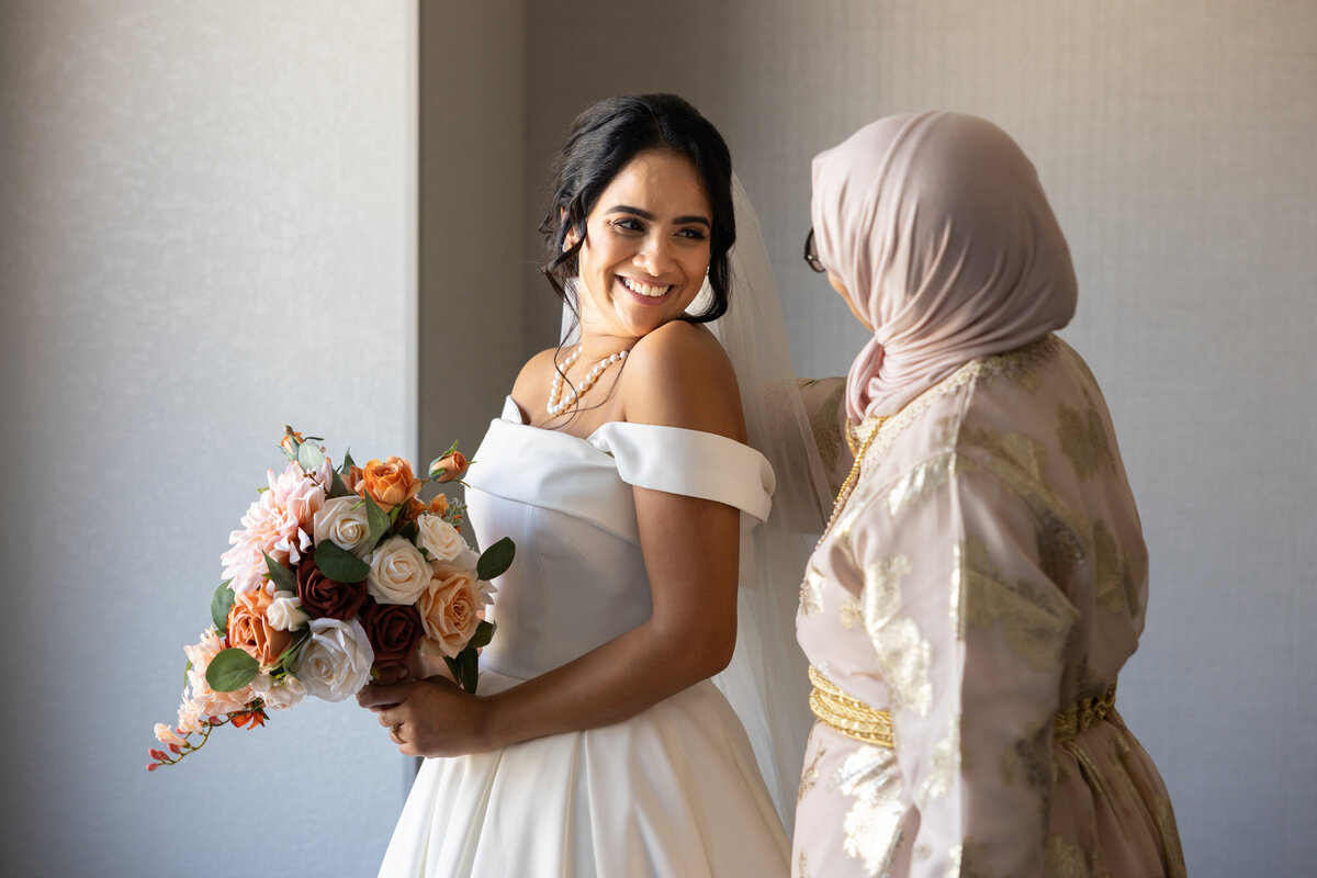 Bride and family member share a special moment while getting ready on her wedding day. Wedding located at Hilton Garden in Ohio. Photographed by Aaron Aldhizer
