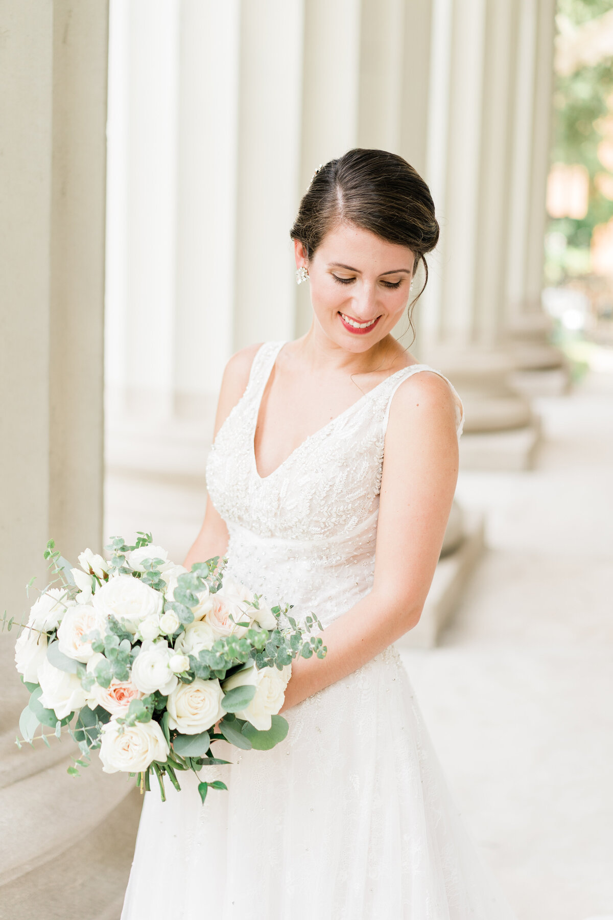 Bride looking down with white bouquet in Alabama