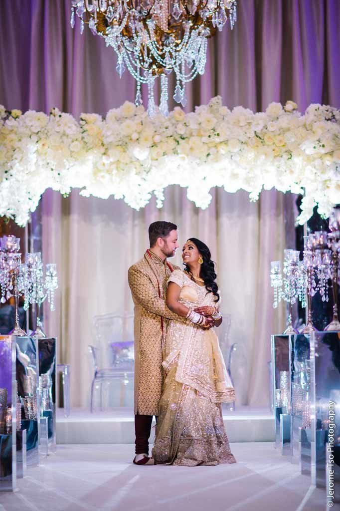 Indian wedding couple in front of grand white wedding arbor at Fairmont Olympic Hotel Seattle wedding