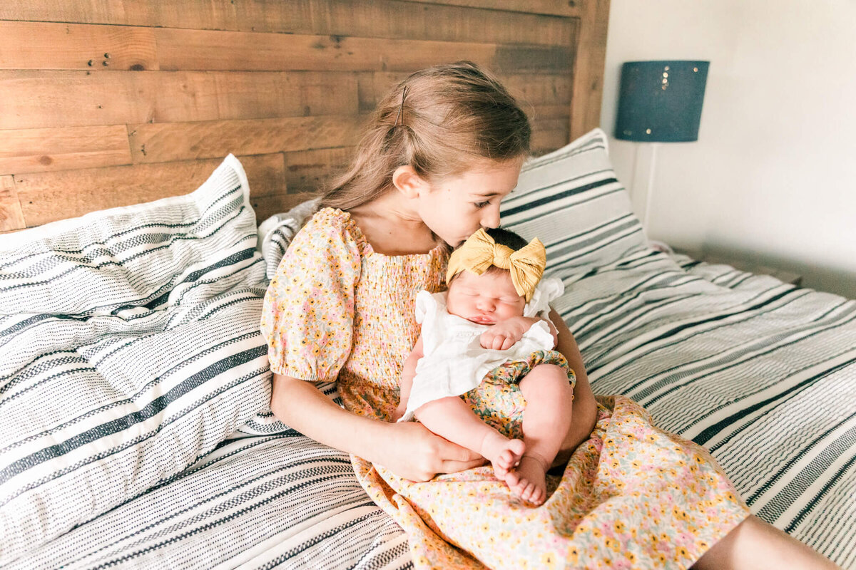 Sister kissing babys head