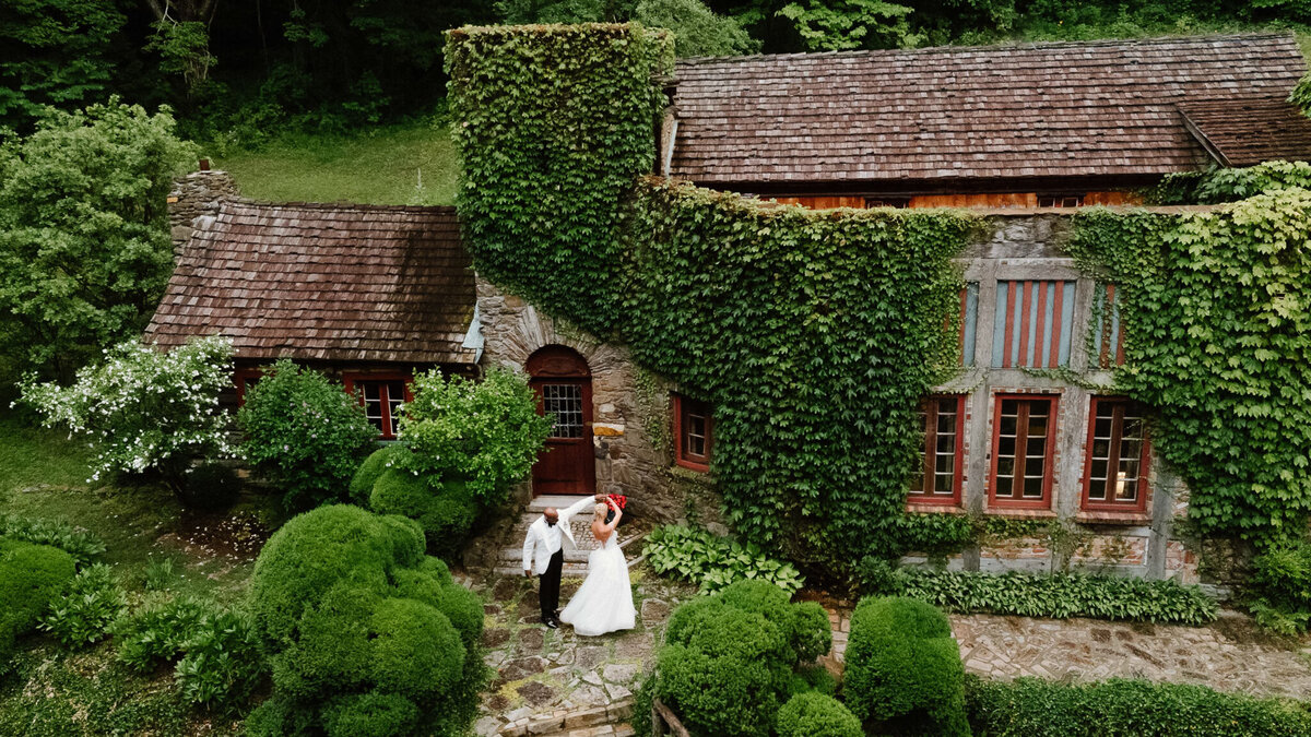 bride and groom dance in front of historic home