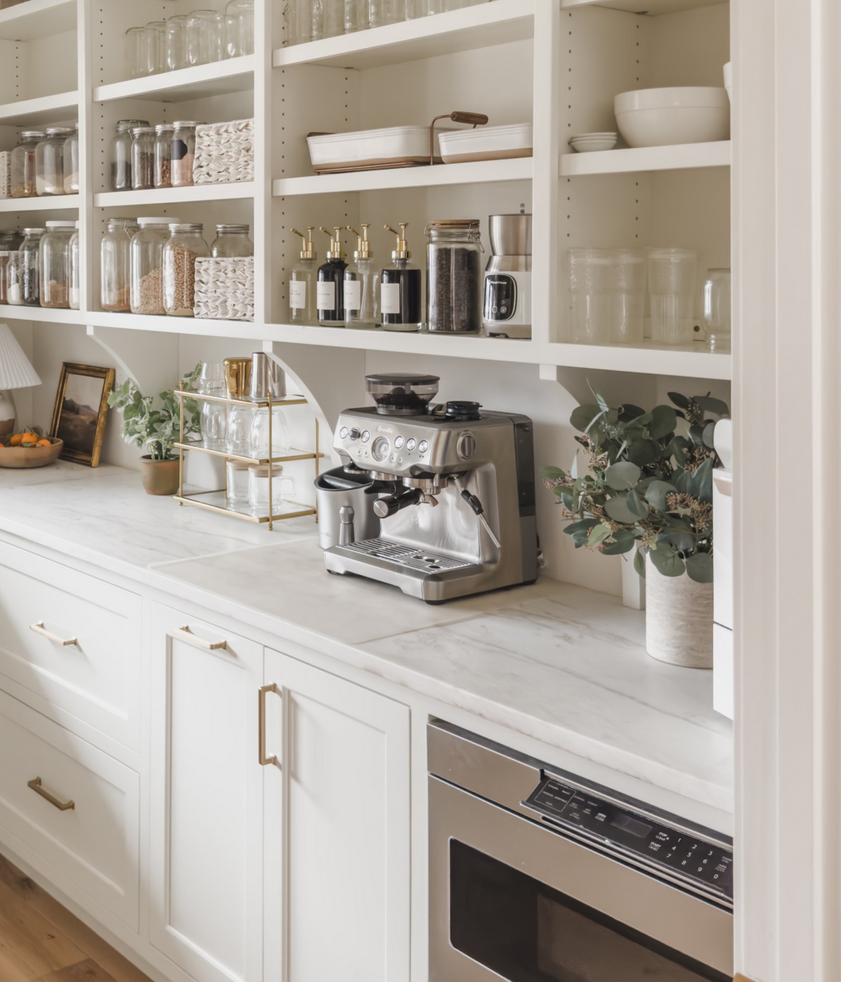 A coffee bar is a central feature in the prep kitchen with open shelving for condiments