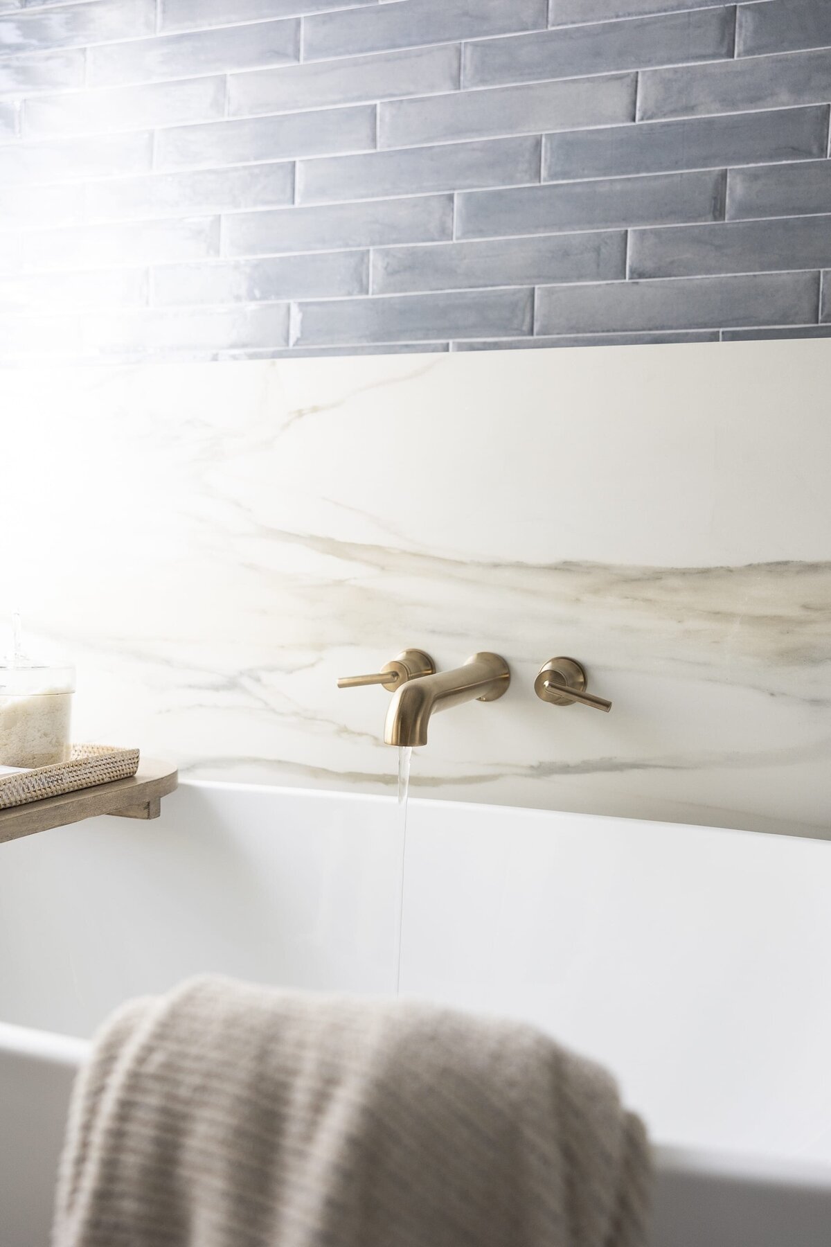 dewine design orlando interior designer contemporary coastal primary bathroom tub faucet with marble and blue tile wall