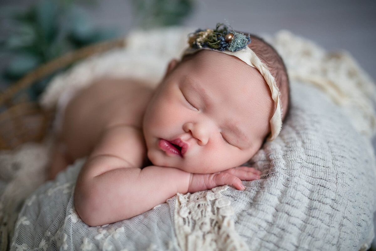 Close up portrait of baby girls face and lips with sleeping on a neutral colored blanket 