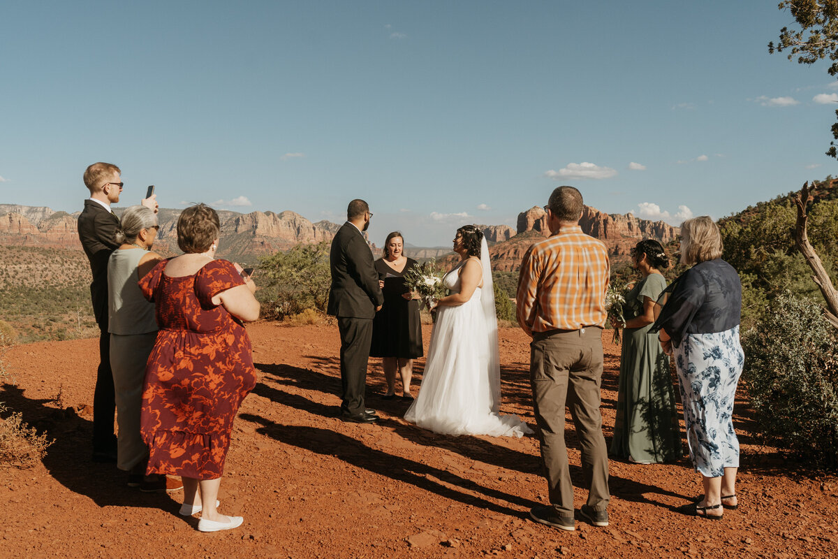 Wedding guests gathered around a couple during their wedding ceremony 