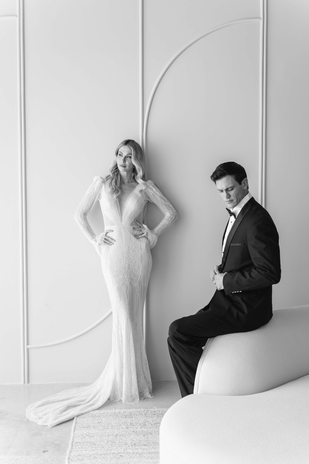 balck and white photo of a bride and a groom, she is standing he is sitting down