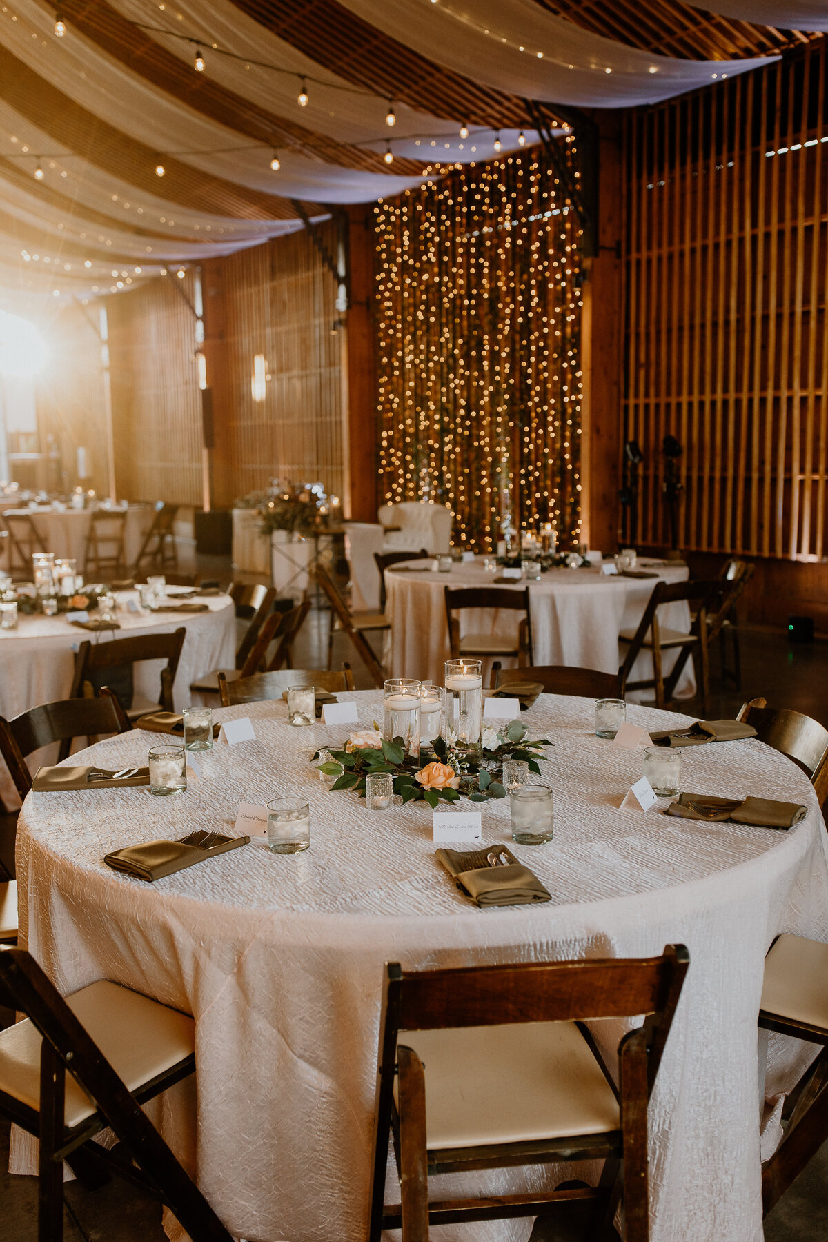 Circular wedding reception tables decorated with small flowers.