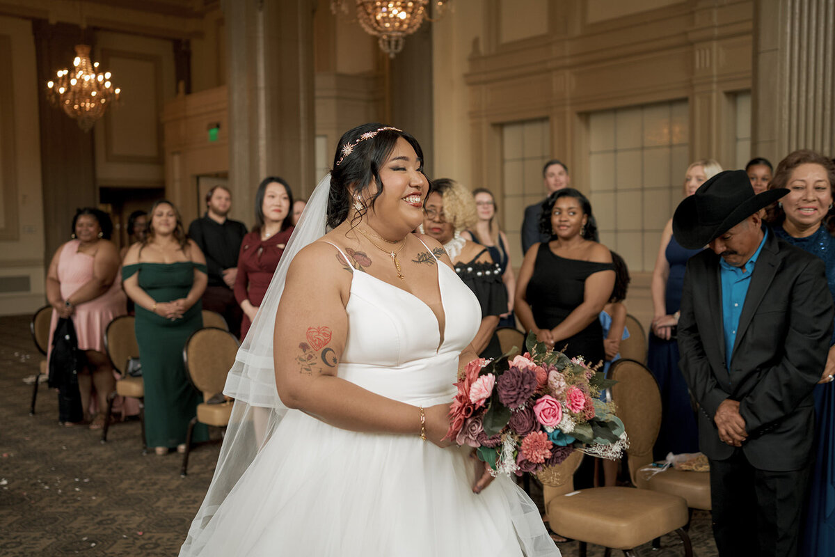 smiling spouse to be walking down the aisle wedding ceremony