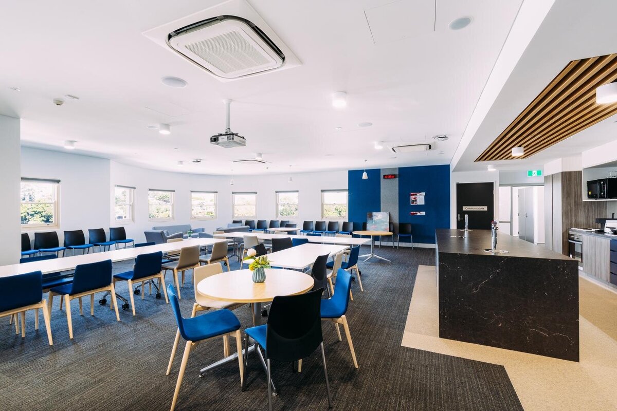 Interior view of Marist Catholic College classroom featuring blue accent wall, collaborative student desks, and natural lighting.
