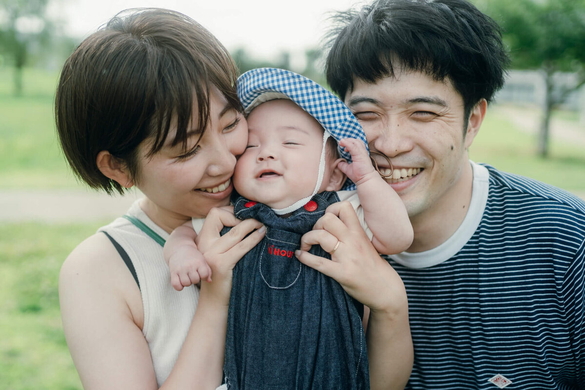 赤ちゃんに顔をに顔を寄せる夫婦