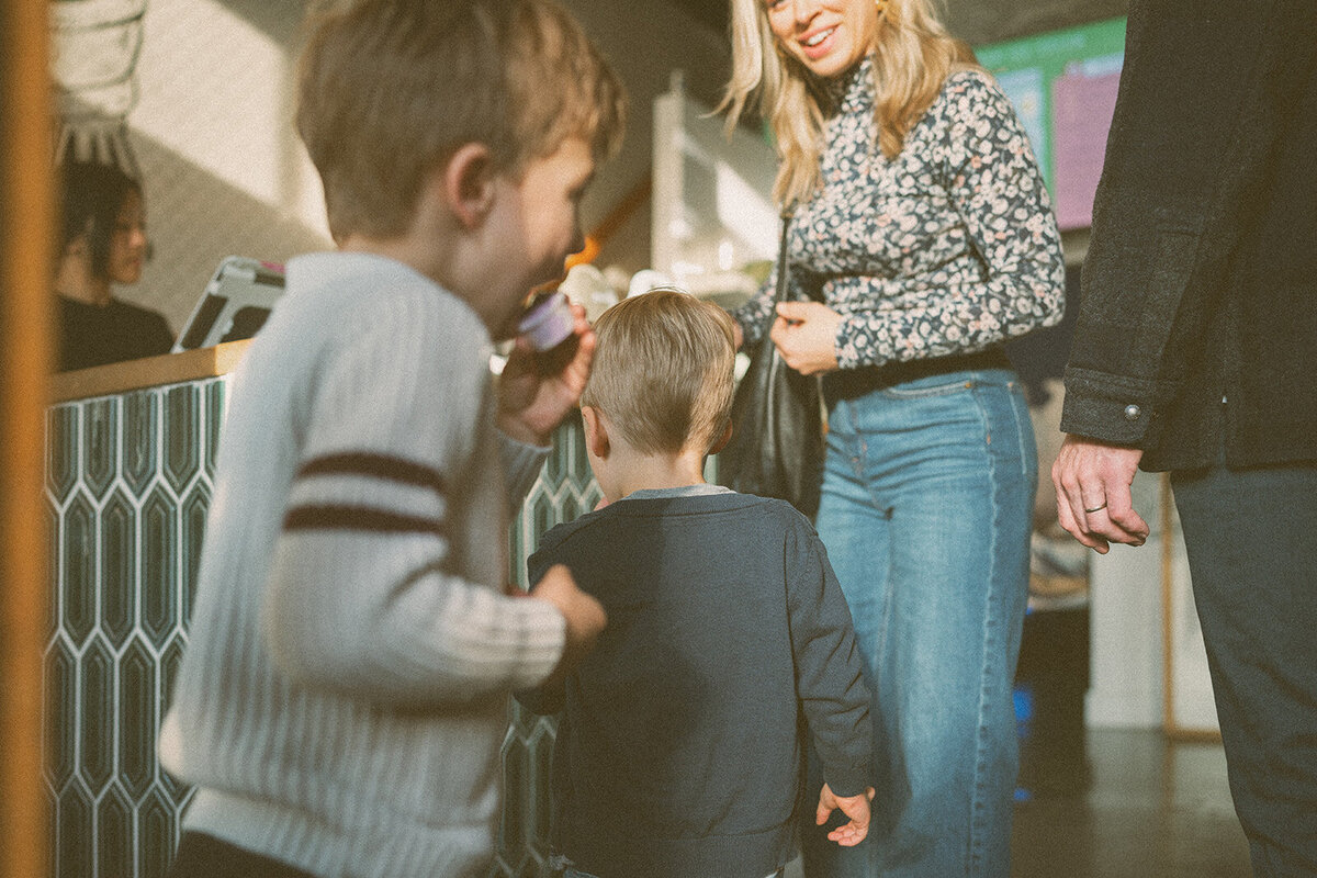 Candid photo of two young brothers enjoying ice cream indoors during a lifestyle family session in Orange County — warm light and true-color edit.