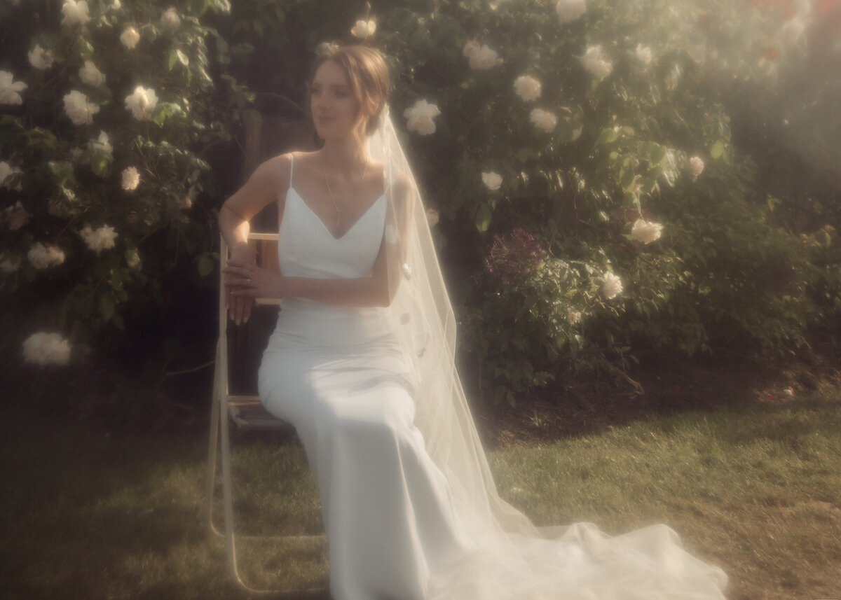bride posing beside rose bush