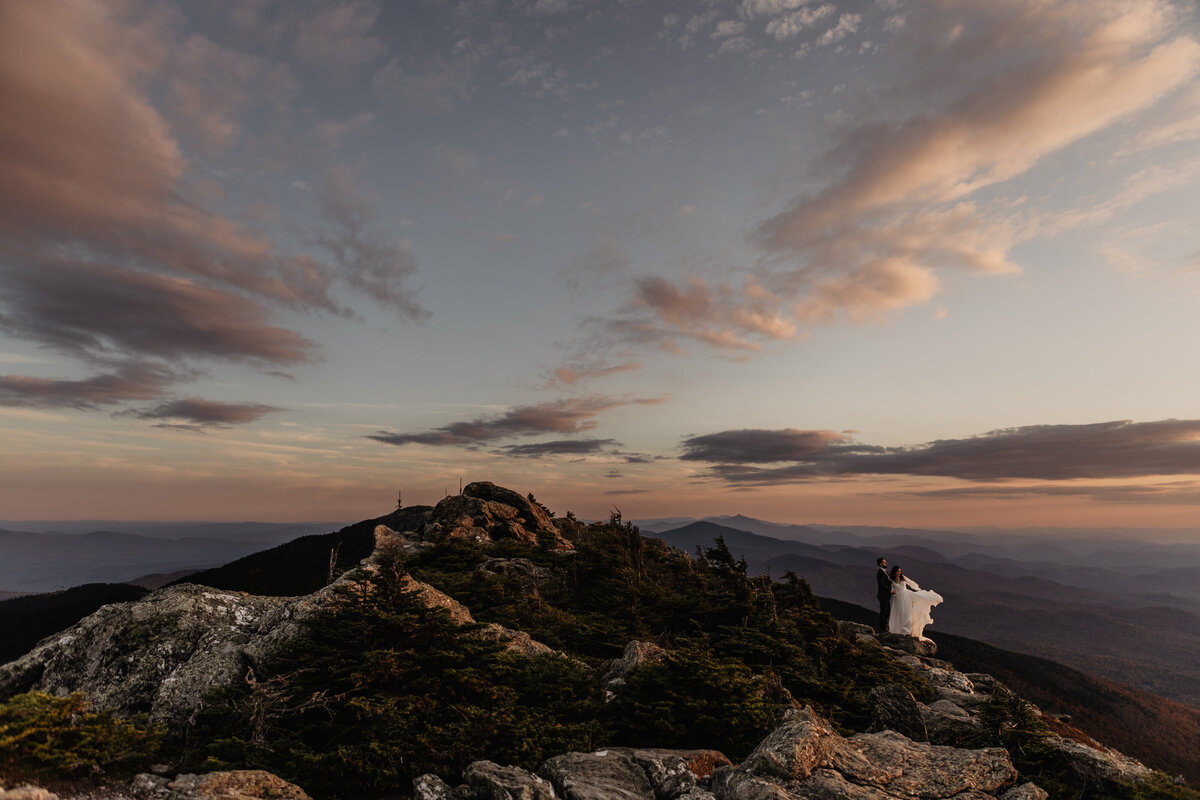 Bride and groom standing on top of Mount Mansfield in Stowe, Vermont