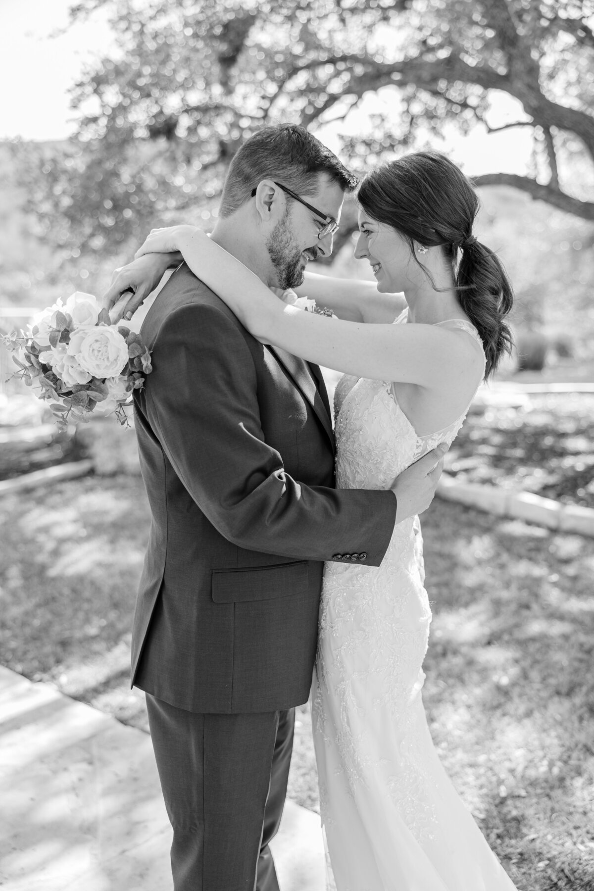 bride and groom stand face to face touching foreheads in black and white by wedding photographer in texas