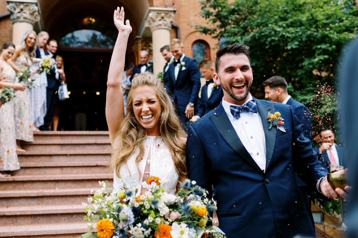 Bride and groom walking out of church married greeted with confetes