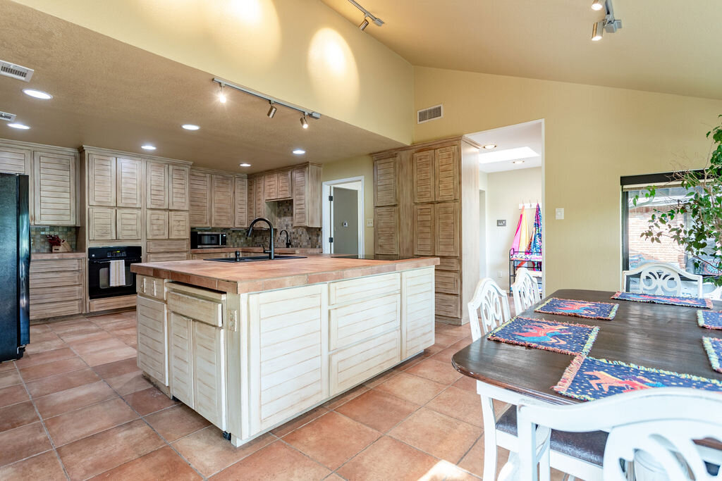 Large kitchen and open concept dining room in this 5-bedroom, 4-bathroom vacation rental house for 16+ guests with pool, free wifi, guesthouse and game room just 20 minutes away from downtown Waco, TX.