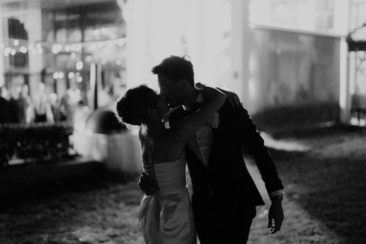 moody photo bride and groom kissing in front of Matilda Bay Restaurant