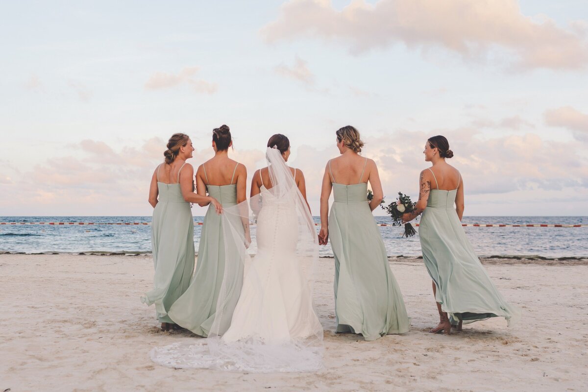 Bridesmaids from behind on beach at wedding in Riviera Maya