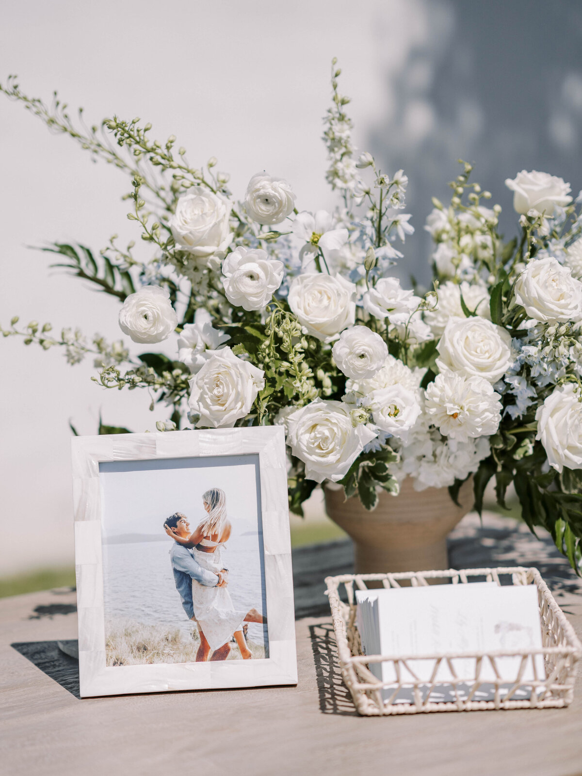 This guest list table is adorned with a big bright welcoming flower arrangement.