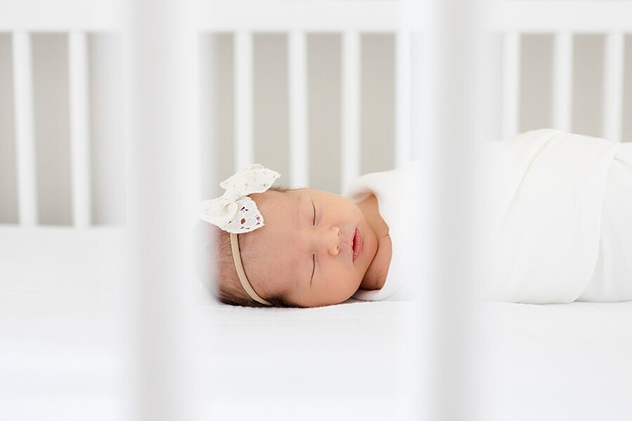 baby sleeping in crib seen through crib slats by DC Newborn Photographer Emily