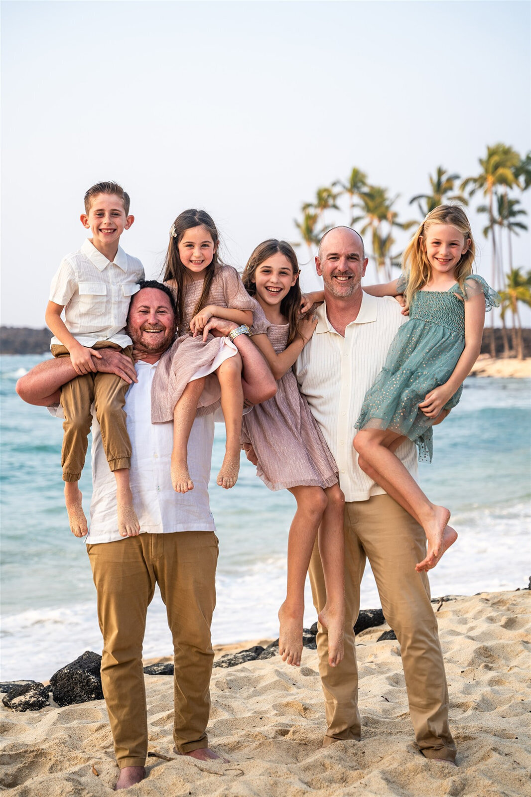 Family smiling on the beach for big island family photographers
